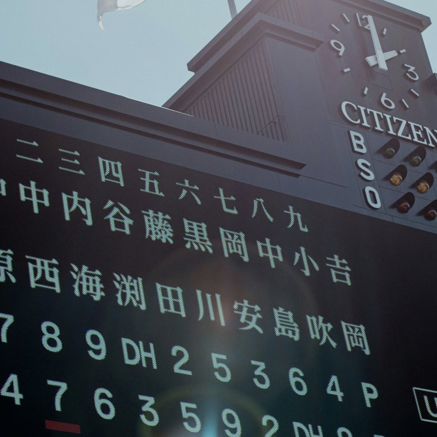 A Japanese stadium scoreboard in the afternoon sun