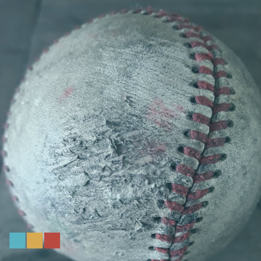 A worn, red-stitched baseball up close